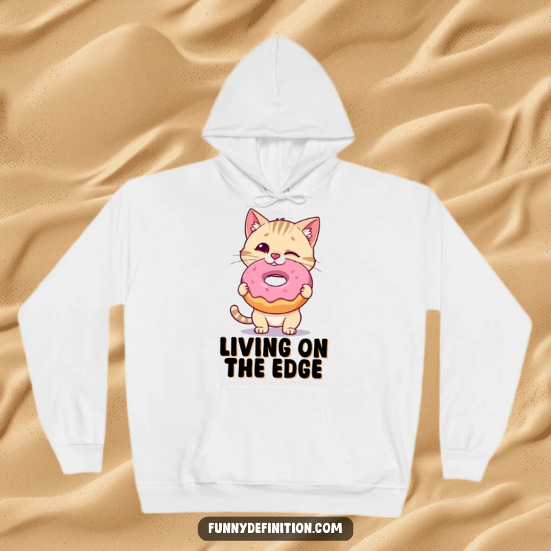 Funny Cat Hoodie: A wobbly cat tries to keep a giant donut balanced on its nose, radiating cute determination and a love for sweets, ideal funny gift.