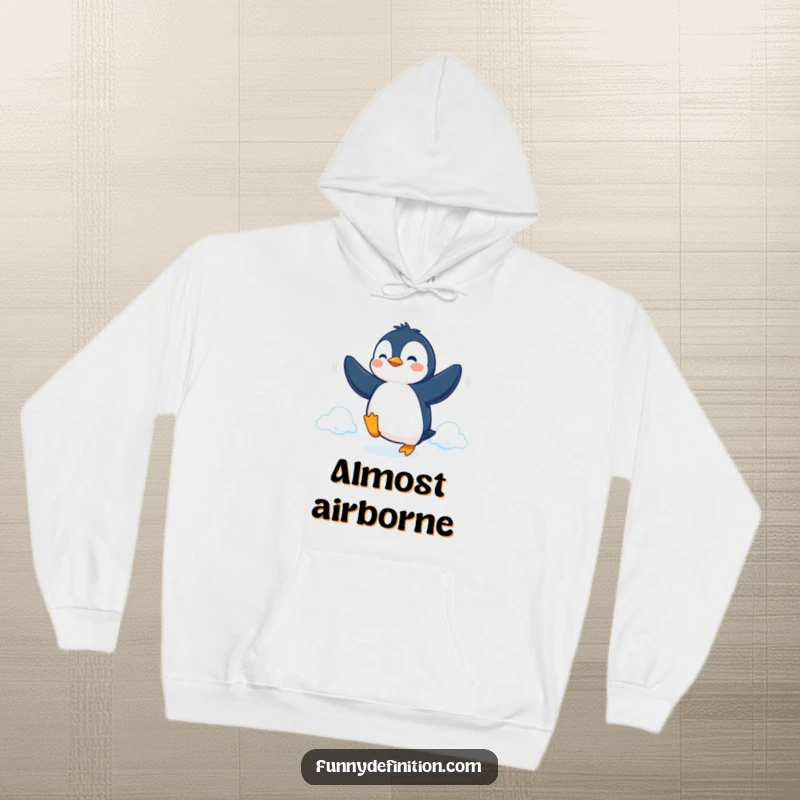 Funny Hoodie featuring a determined penguin attempting flight with flippers, offering cozy inspiration and humor.